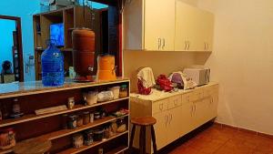 a kitchen with a counter and cabinets and a stool at Hostel Recanto Caiçara in São Sebastião