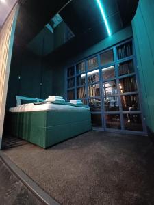 a bedroom with a green bed in a room with a window at apartament centrum-rynek Gorzów in Gorzów Wielkopolski