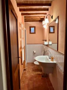 een badkamer met een witte wastafel en een spiegel bij Relax in Chianti IL BORGO 7 in Montespertoli