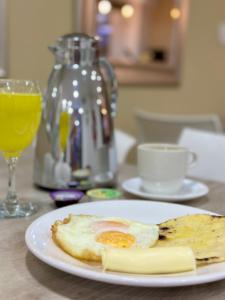a plate of food with an egg and cheese on a table at Laureles Guest House in Medellín