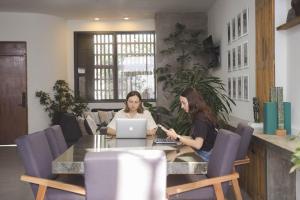 two women sitting at a table with a laptop at CASA LUMBA in Guadalajara