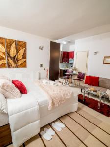a bedroom with a large white bed and a living room at Comfy and Cosy Studio Kalamata in Kalamata