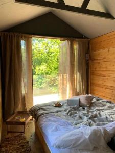 a bedroom with a large bed with a window at The Boatshed at Camp Plas in Welshpool