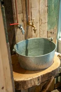 une baignoire en métal assise au-dessus d'une table en bois dans l'établissement The Boatshed at Camp Plas, à Welshpool