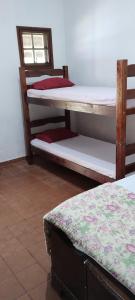 a room with two bunk beds and a window at Hostel Recanto Caiçara in São Sebastião