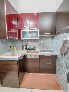 a kitchen with red cabinets and a sink at Comfy and Cosy Studio Kalamata in Kalamata