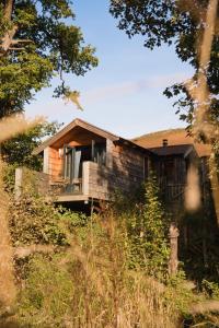 Cette maison en bois dispose d'une terrasse couverte et d'un balcon. dans l'établissement The Boatshed at Camp Plas, à Welshpool