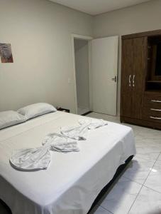 um quarto com uma cama com um cobertor branco em Linda casa completa confortável em Foz do Iguaçu