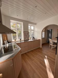 una grande cucina con pavimenti in legno e piano di lavoro di Jonas Hus - Munkgaard Bed & Breakfast a Store Heddinge
