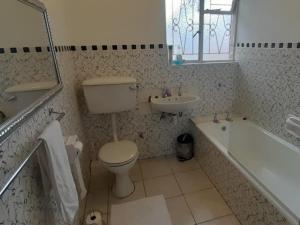 a bathroom with a toilet and a tub and a sink at Step-by-Step Self-Catering and B&B in Bellville