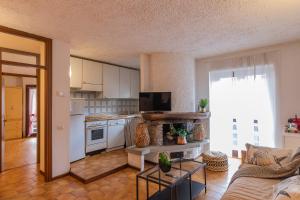 a living room with a couch and a kitchen at [IHost Flat] - Valmalenco Marconi 33 in Chiesa in Valmalenco