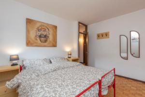 a bedroom with a bed and a painting on the wall at [IHost Flat] - Valmalenco Marconi 33 in Chiesa in Valmalenco