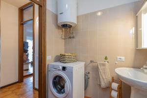 a bathroom with a washing machine and a sink at [IHost Flat] - Valmalenco Marconi 33 in Chiesa in Valmalenco