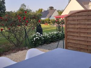 a view of a garden with a fence and roses at La Maison d'Iris in Surzur