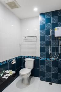 a bathroom with a toilet and a blue tiled wall at Nine blue residence in Nong Prue