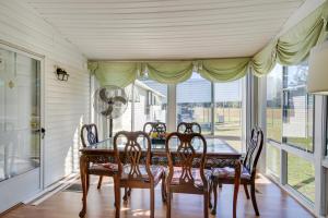 a dining room with a table and chairs and windows at Spacious South Carolina Abode with Hot Tub and Grill! in Columbia