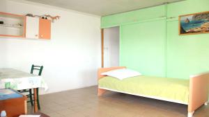 1 dormitorio con 1 cama con pared verde en House Biondina, en Vela Luka