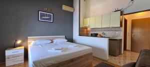 a small bedroom with a bed and a kitchen at Apartment Moli Onte Holiday in Milna