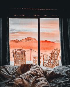a painting of chairs and a bed in a room at Wadi Rum Rose camp in Wadi Rum