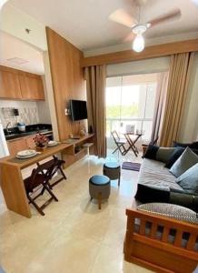 sala de estar con sofá, mesa y cocina en CALDAS NOVAS - RECANTO DO BOSQUE Flat Service AP209 en Caldas Novas