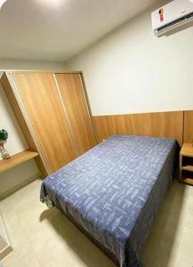 1 dormitorio con 1 cama azul en una habitación en CALDAS NOVAS - RECANTO DO BOSQUE Flat Service AP209, en Caldas Novas