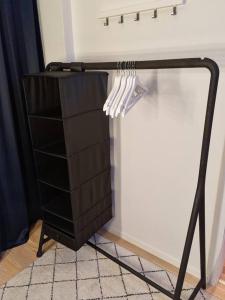 een zwart rek met witte gebruiksvoorwerpen aan de muur bij NEW modern apartment at Solsiden in Trondheim