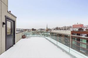 een met sneeuw bedekt balkon met uitzicht op de stad bij NEW modern apartment at Solsiden in Trondheim