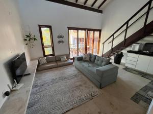 ein Wohnzimmer mit Sofa und Fernseher in der Unterkunft Taiba Beach Resort - Apt Duplex Novo in Taíba