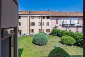- une vue sur un bâtiment avec une cour agrémentée de buissons dans l'établissement Casa Elena - vicino al Castello - by Host4U, à Pavia