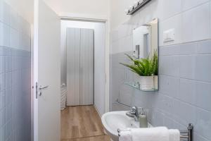 une salle de bain blanche avec un lavabo et un miroir dans l'établissement Casa Golgi - Pavia City - by Host4U, à Pavia