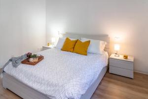 une chambre avec un grand lit avec des oreillers jaunes dans l'établissement Casa Golgi - Pavia City - by Host4U, à Pavia
