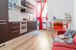 cocina y sala de estar con sofá rojo en Casa Golgi - Pavia City - by Host4U, en Pavia