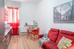 un salon avec un canapé rouge et une table dans l'établissement Casa Golgi - Pavia City - by Host4U, à Pavia 22 autres photos