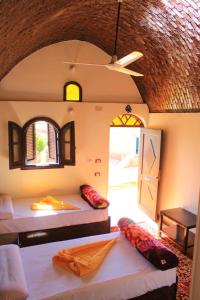 een kamer met 2 bedden in een kamer met een raam bij KoshTaka-كوشتاكا in Naj‘ al Maḩaţţah