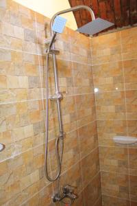 een douche met een douchekop in de badkamer bij KoshTaka-كوشتاكا in Naj‘ al Maḩaţţah