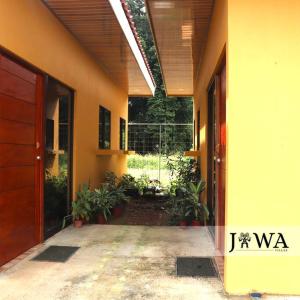 een gang van een huis met een deur en planten bij Villas Jawa in Puerto Limón