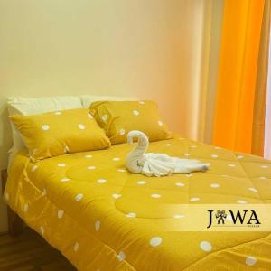 a swan on a yellow bed with polka dots at Villas Jawa in Puerto Limón