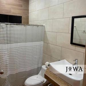 een badkamer met een wit toilet en een wastafel bij Villas Jawa in Puerto Limón