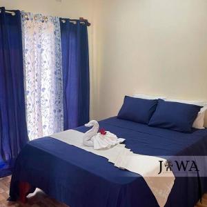 een slaapkamer met een bed met een zwaan erop bij Villas Jawa in Puerto Limón