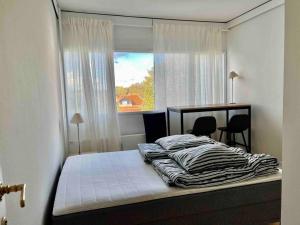 een bed in een kamer met een raam en een bed sidx sidx sidx bij Skøn arkitekt tegnet ferie lejlighed in Charlottenlund