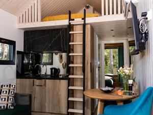 a tiny house with a kitchen and a dining room at Magia Lasu Borków - Korony Drzew in Kielce