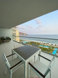 a dining table and chairs on a balcony with the ocean at Peninsula 12 D in Ixtapa