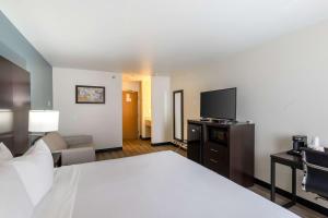 a hotel room with a bed and a flat screen tv at Quality Inn Winslow I-40 in Winslow