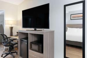 Habitación de hotel con TV y cama en Quality Inn Idaho Falls en Idaho Falls