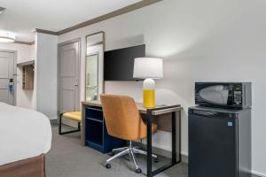 a room with a desk with a television and a chair at Comfort Inn in Plainwell