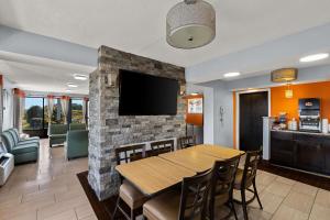 une salle à manger avec une table et une télévision sur un mur en briques dans l'établissement Econo Lodge White Pine Morristown I-81 & I-40 Split, à White Pine