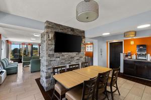 a dining room with a table and a tv on a brick wall at Econo Lodge White Pine Morristown I-81 & I-40 Split in White Pine