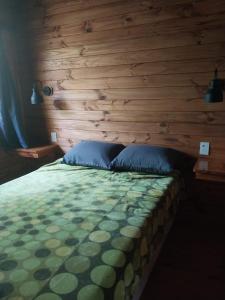 a bed in a room with a wooden wall at Cabañas Sidharta in Tigre +74 photos