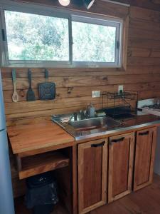a kitchen with a sink and a wooden counter at Cabañas Sidharta in Tigre