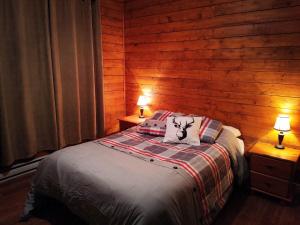 een slaapkamer met een bed met twee lampen op twee tafels bij Chalets du Domaine - RUSTIQUE in Notre-Dame-Des-Bois